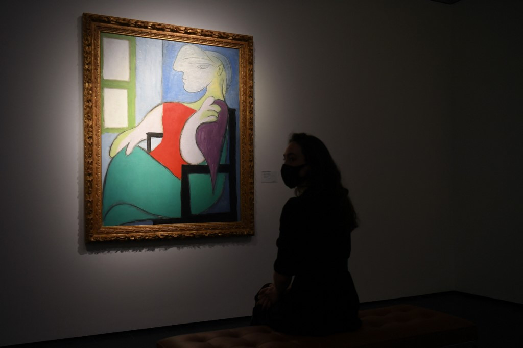パブロ・ピカソの≪Femme assise près d'une fenêtre (Marie-Thérèse)≫の前に女性が立っている