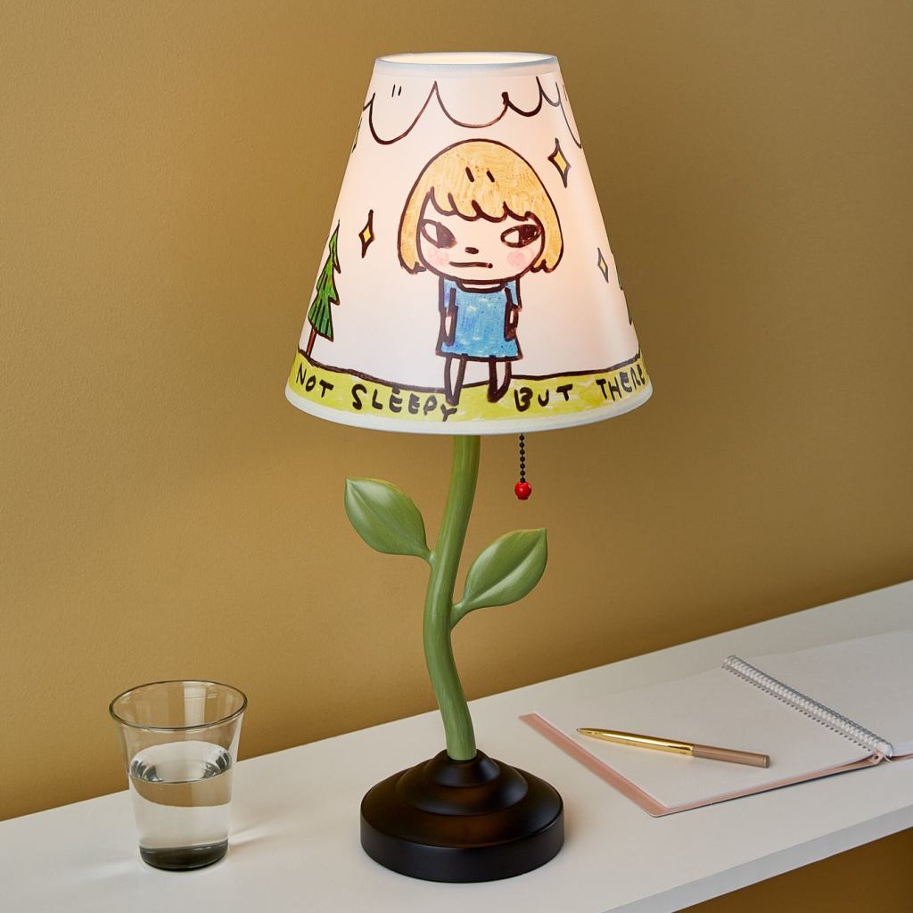 MoMA Design Storeから発売される奈良美智デザインのテーブルランプ。枝の葉をイメージしたスタンドに、奈良美智のアートワークをシェードに施されている。